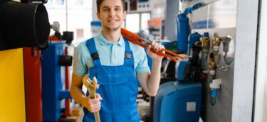 Plumber shows pipe wrenches in plumbering store